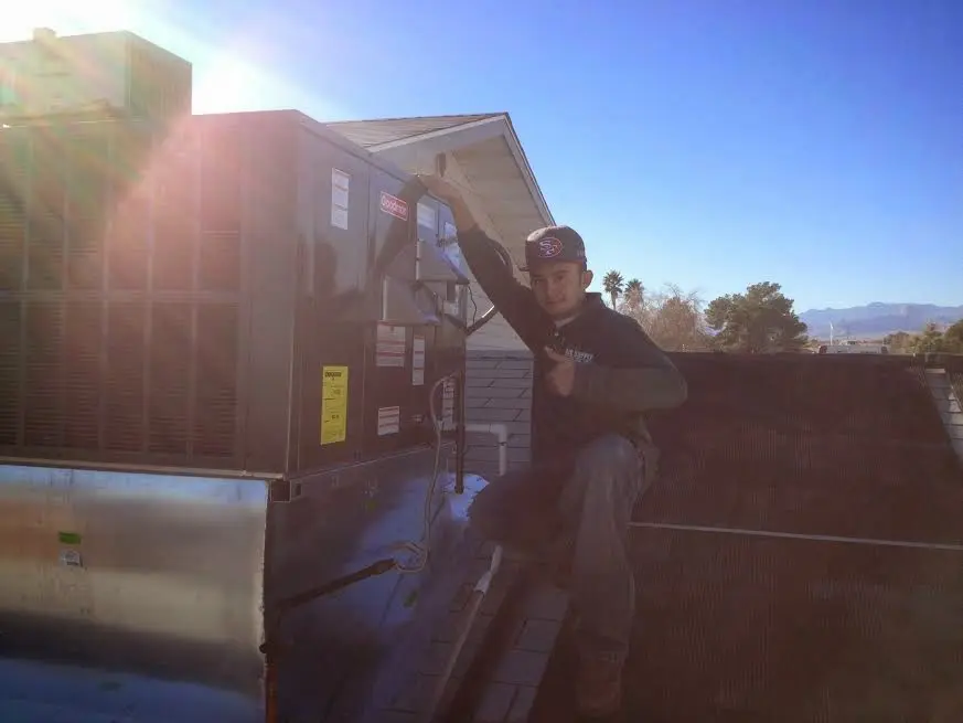 HVAC technician performing Heat Pump Repair on a rooftop unit in Brooklyn